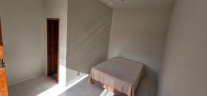 Una pequeña habitación blanca con un banco en la esquina. en Casa Temporada Lua Nova, en Guriri 17 fotos más