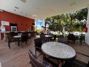 a restaurant with tables and chairs and a bar at GUARAJUBA Porto Smeralda Flat in Guarajuba