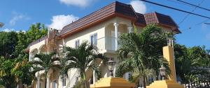 a white house with palm trees in front of it at Sorina's Apartments in Ocho Rios