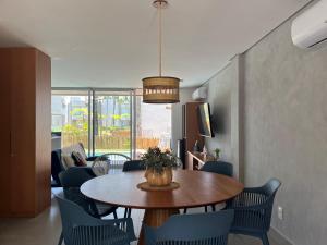 a dining room with a table and blue chairs at Casa G9 - Naluum Residence in Passo de Camarajibe