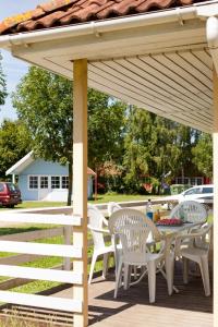 einen Tisch und Stühle unter einer weißen Pergola in der Unterkunft Ferienpark Markgrafenheide in Markgrafenheide