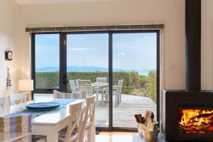 a dining room with a table and a fireplace at Southerlys Beach House in Dolphin Sands