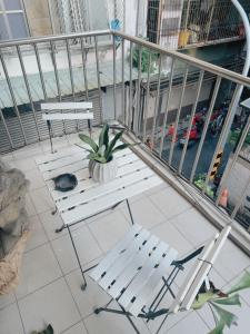 a balcony with two chairs and a table and a plant at Sunday Inn in Tainan