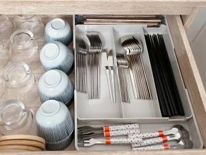 a drawer filled with dishes and utensils at 夕日と海の貸切宿 海しずく in Kami Amakusa