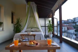 a table with a plate of food on a balcony with orange juice at Lakeview Balcony in Kastoria in Kastoria