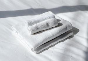 a stack of white towels sitting on a bed at trias527 1-1 in Tokyo +40 photos