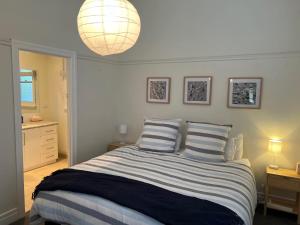een slaapkamer met een bed met 2 gestreepte kussens bij Saltwater Bungalow - WiFi in Robe
