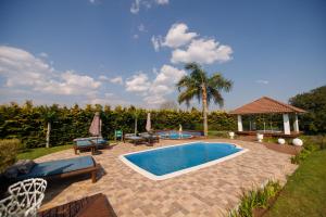 a swimming pool with chairs and a gazebo at Rancho P&R in Balsa Nova