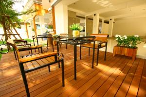 a patio with a table and benches on a deck at At Home Phetkasem in Bangkok