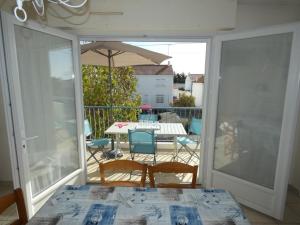 a patio with a table and chairs and an umbrella at Notre Dame de Monts (85) - Location Appartement 50m² environ - 6 personnes - FR-1-540-4 in Notre-Dame-de-Monts