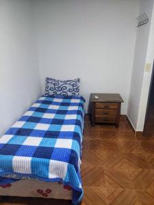 a bedroom with a blue and white bed and a table at Araucaria in Puerto Esperanza