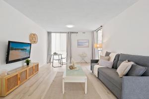 ゴールドコーストにあるCozy Central Beachfront Surfers Paradiseのソファとテレビのあるリビングルーム