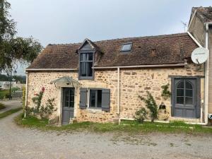 an old brick house with black doors and windows at La Ptite maison du Canal in Drevant