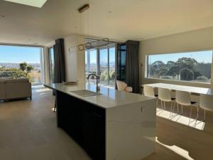 a kitchen and living room with a counter and some windows at Location and luxury in Timaru in Timaru