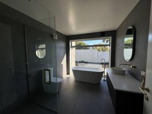 a bathroom with a tub and a large window at Location and luxury in Timaru in Timaru