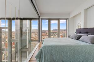 een slaapkamer met een groot bed en glazen ramen bij Penthouse With The Best Views! in Barcelona