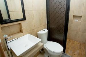 a bathroom with a toilet and a sink and a shower at posada la entrega in Bahías de Huatulco