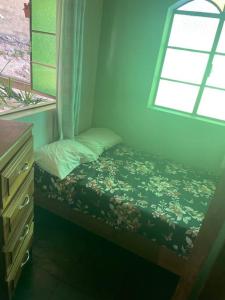 a small bed in a room with a window at Casa do coqueiro in Diamantina