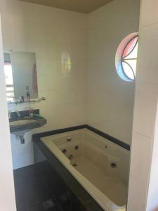 a bathroom with a large bath tub and a sink at Casa do coqueiro in Diamantina +21 photos
