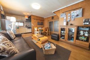 a living room with a leather couch and a table at Motomachi House helps guests book great restaurants in Furano in Shimo-furano