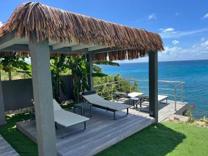a gazebo with chairs and a view of the ocean at condostmaarten by the sea -Adults Only- in Koolbaai