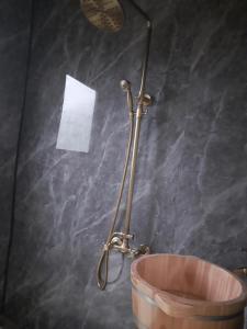 a shower in a bathroom with a bucket at Hương Siu homestay in Mù Cang Chải
