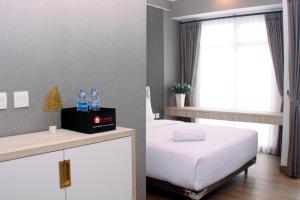 Postel nebo postele na pokoji v ubytování Modern Look and Restful Studio at 32th Floor Vasanta Innopark Apartment By Travelio