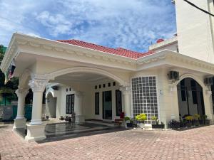 una casa blanca con techo rojo en De Nusantara Hotel Syariah, en Medan