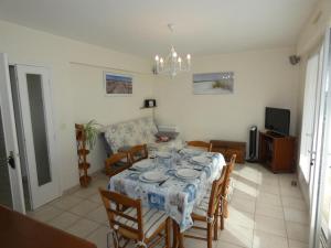 a dining room with a table and chairs at Notre Dame de Monts (85) - Location Appartement 50m² environ - 6 personnes - FR-1-540-4 in Notre-Dame-de-Monts
