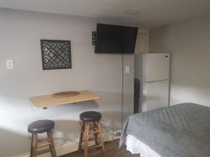 a kitchen with a refrigerator and two bar stools at Cozy Eco Studio in Ottawa