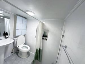 a white bathroom with a toilet and a sink at Clean & All new - Songridan-gil, Seokchon Lake, Lotte World, KSPO Dome, Olympic Park, Han River, Asan Hospital, Coex in Seoul