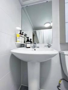 a white bathroom with a sink and a mirror at Clean & All new - Songridan-gil, Seokchon Lake, Lotte World, KSPO Dome, Olympic Park, Han River, Asan Hospital, Coex in Seoul