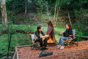 箱根町にあるkoti hakone（コティ箱根）の火の周りに座る二人