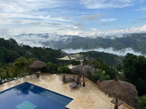 a swimming pool with a view of the mountains at Entre Verdes Hotel & Glamping in Medellín