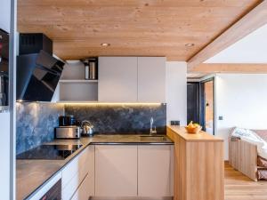 a kitchen with white cabinets and a wooden ceiling at Appartement de standing 4 pièces, SPA, parking, Les Saisies - FR-1-810-10 in Les Saisies