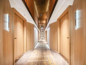 a long corridor with wooden cabinets and a long hallway with ceilings at Yiwu Yunjing Hotel in Yiwu