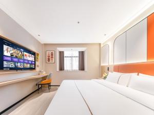 a hotel room with a large bed and a tv at Yiwu Yunjing Hotel in Yiwu