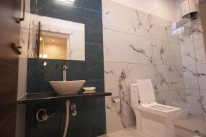 a bathroom with a sink and a toilet and a mirror at The Sawai Heritage in Sawāi Mādhopur +18 photos