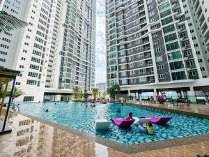 a swimming pool with people sitting in chairs in a building at Studio Stay in Kuala Lumpur