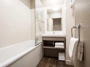 a white bathroom with a sink and a shower at Hotel Lille Europe in Lille +43 photos