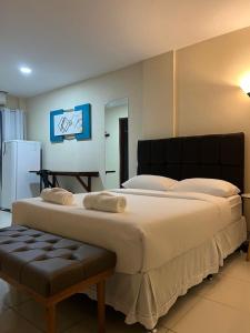 a bedroom with a large bed with a large white bedspread at Pousada Himura in Angra dos Reis