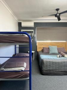 a room with two bunk beds and a ceiling fan at Kalbarri Inn in Kalbarri