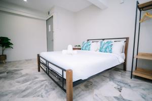 Un dormitorio con una gran cama blanca con almohadas azules. en Swing & Pillows - Seri Kembangan Selangor, en Seri Kembangan