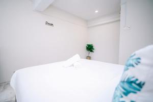 une table blanche dans une pièce avec une plante dessus dans l'établissement Swing & Pillows - Seri Kembangan Selangor, à Seri Kembangan