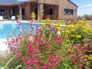 un giardino fiorito accanto a una piscina di Chambre 4 pers avec piscine chauffée & WiFi - FR-1-591-708 a Faverolles