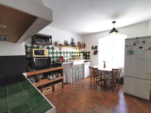 a kitchen with a table and a dining room at Maison de campagne paisible avec terrasse et animaux admis - FR-1-582-505 in Sembadel