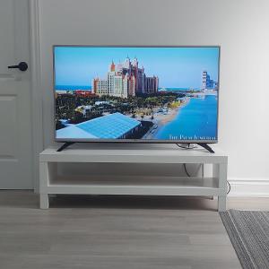 a flat screen tv sitting on a stand in a living room at Bright 2 Bedroom Basement Apartment in Angus in Angus