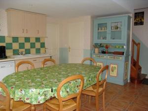 a kitchen with a table and chairs and a kitchen with a table and a table at Chambres élégantes au cœur de la forêt d'Argonne - FR-1-585-138 in Futeau +15 photos