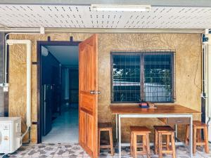 a small house with a table and some stools at Baan Panmala Homestay - Ao Luek, Krabi in Krabi
