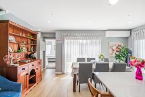 Una cocina y un comedor con mesa y sillas. en Auckland ONE Tree Hill Coby Suite, en Auckland